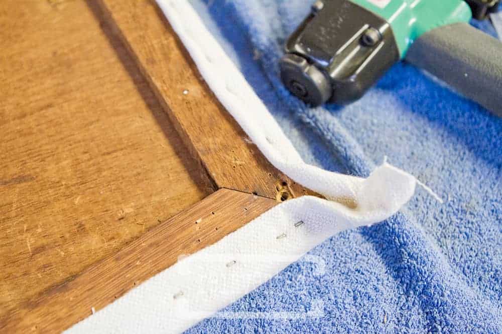 fabric being attached to a dining chair seat for a reupholstery project