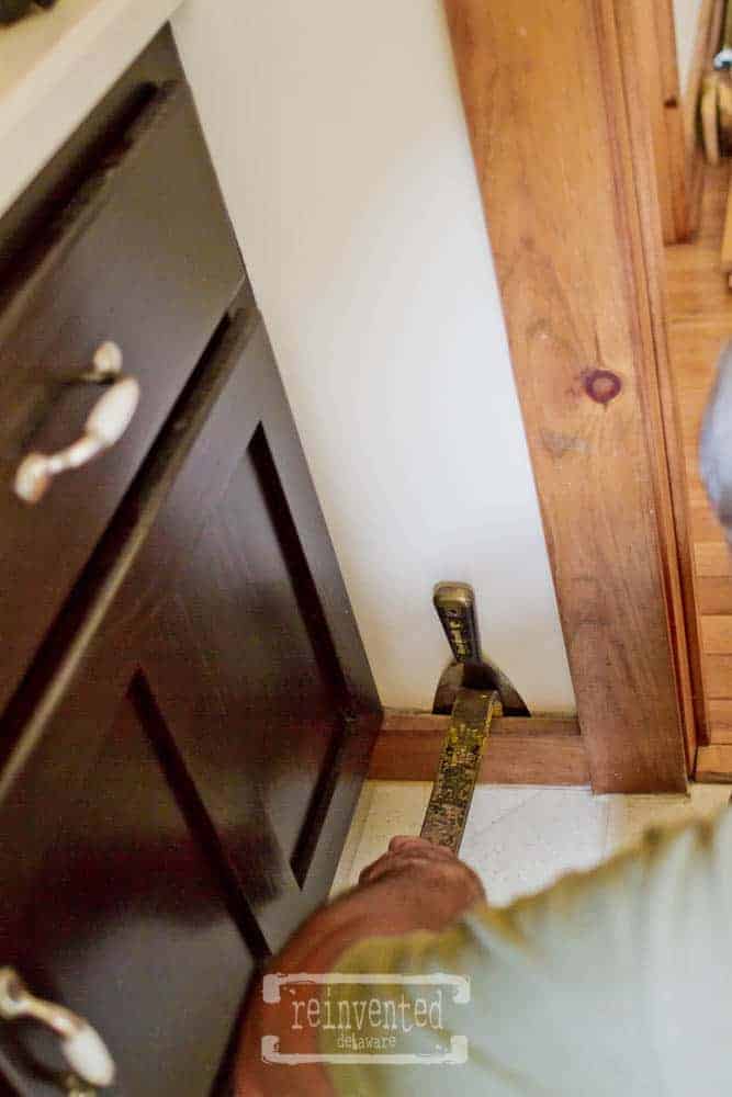 man using crowbar to remove baseboards for a small bathroom makeover