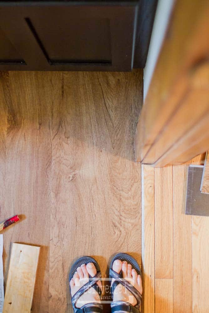 lady standing on newly replaced luxury vinyl tiles in cheap bathroom floor makeover