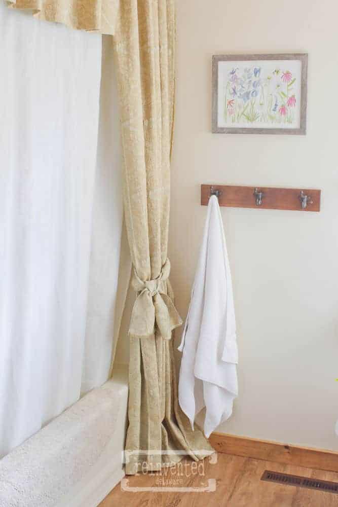 paisly shower curtain hanging near the tub and shower, bathroom floor in Shaw vinyl plank floor
