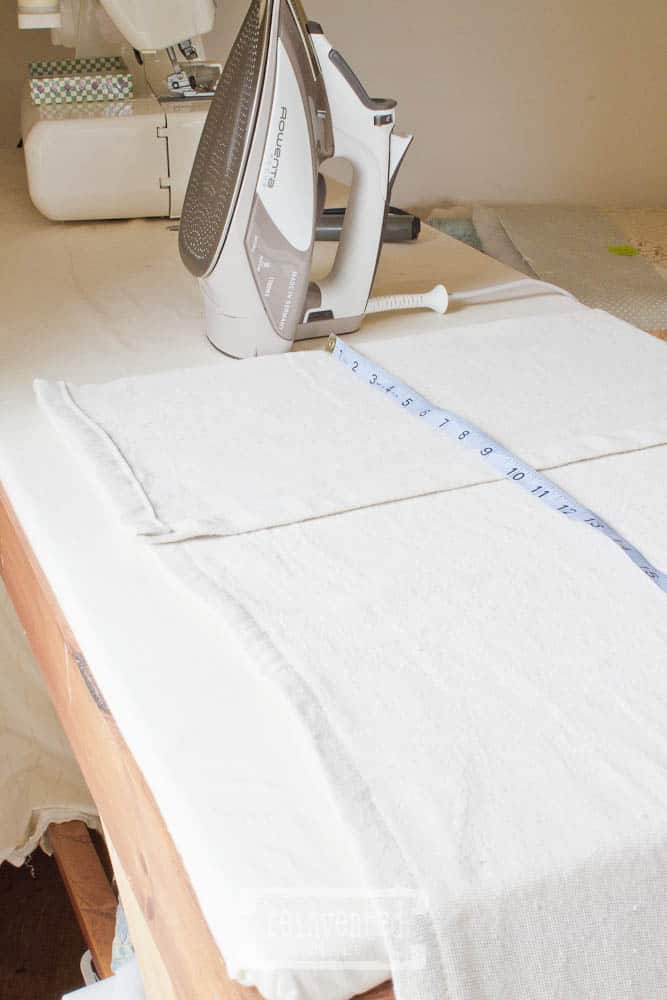 rowenta iron, drop cloth and measuring tape on top of an ironing board