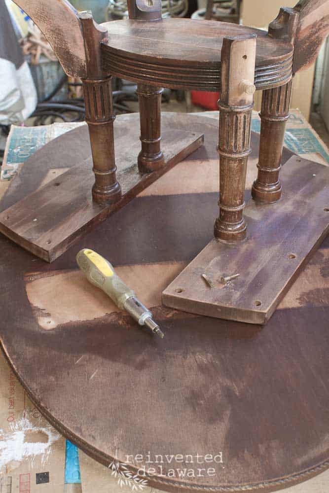 upside down coffee table with screwdriver and loose screws