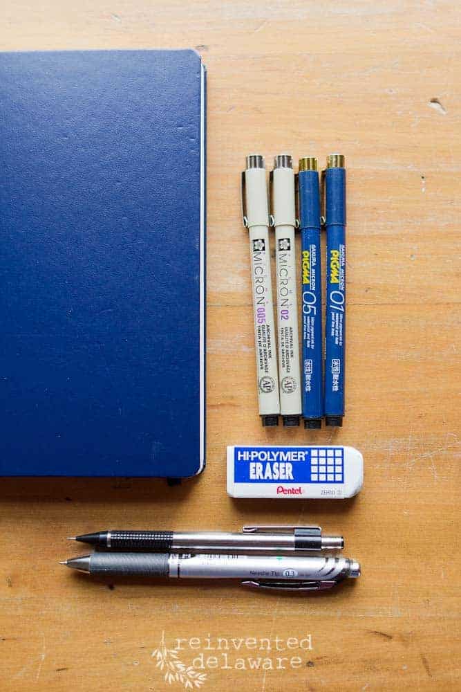 blue bullet journal and various pens