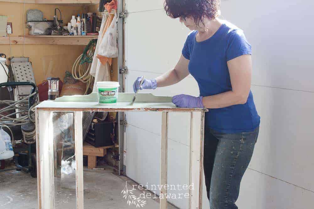 lady applying Ready Strip paint remover on an old china cabinet