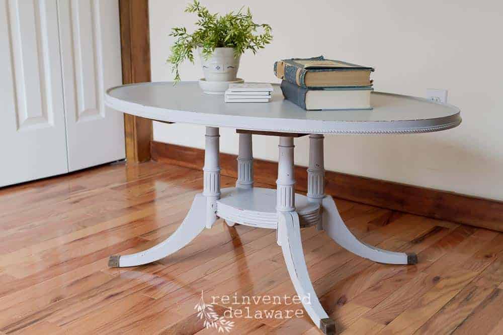 thrift store coffee table makeover in light gray paint staged with home decor