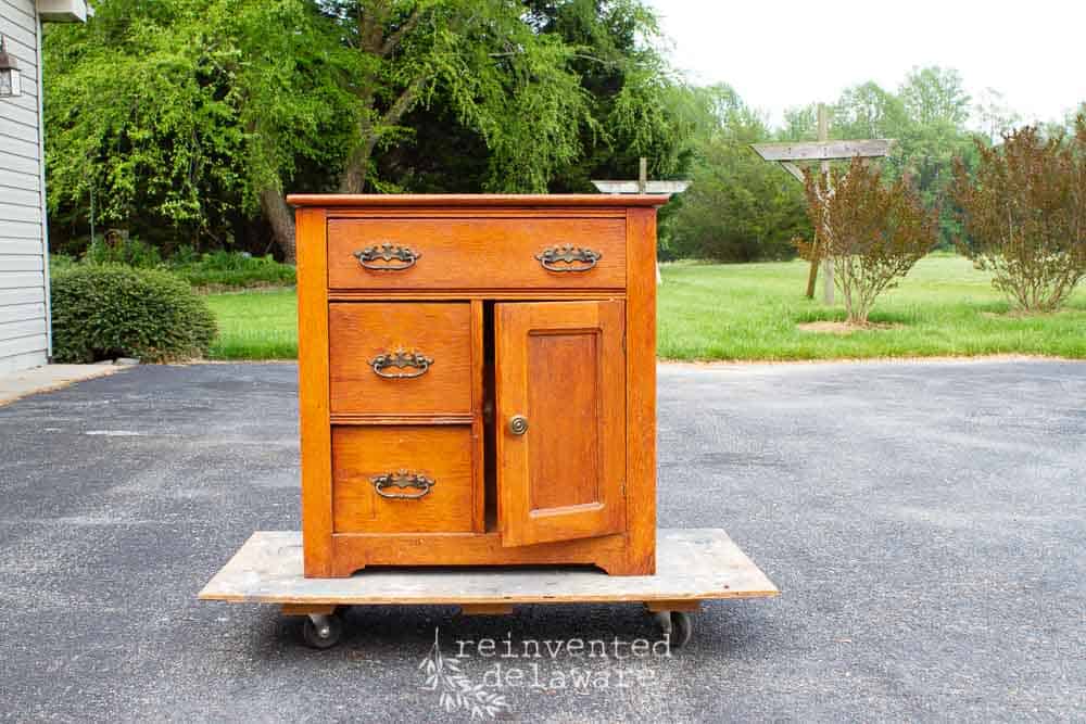 before the makeover image of vintage washstand in original orange toned stain