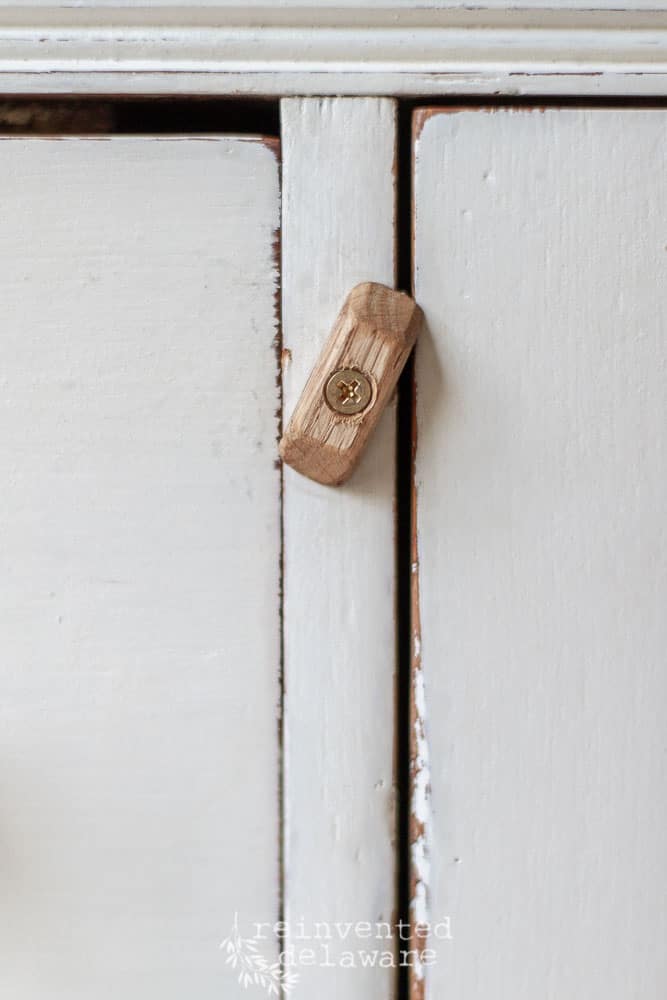 closeup of handmade wooden knob holding door shut on vintage washstand makeover