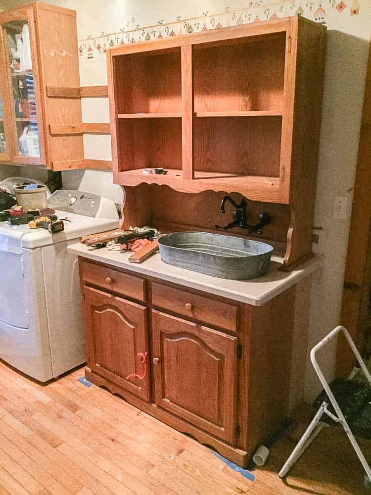 before image of furntiure makeover turning china cabinet into laundry room storage