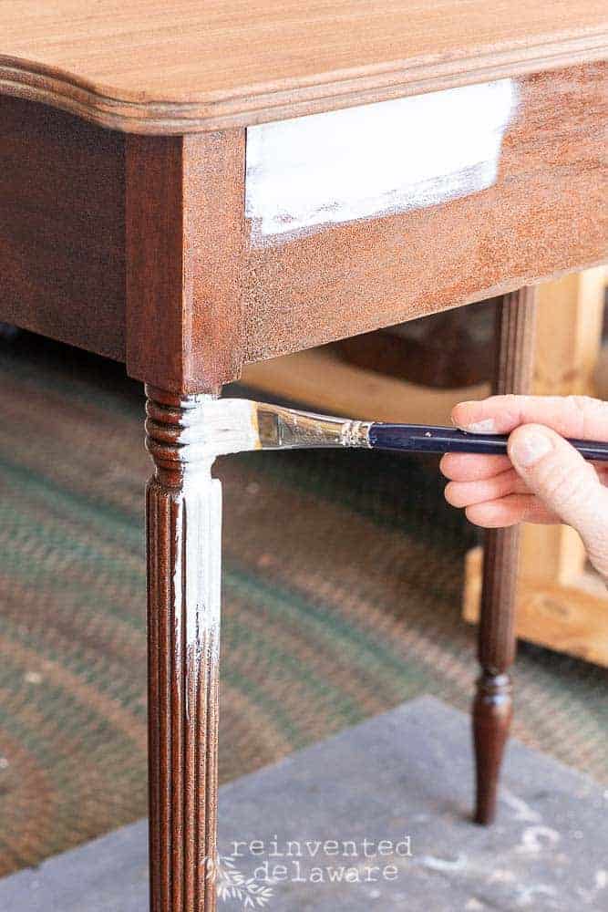 fluted table leg being painted with an artist's paintbrush