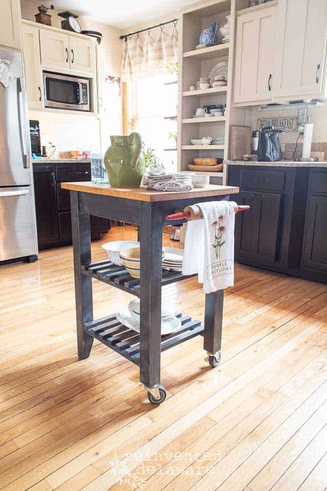 Small kitchen island makeover with rolling pin towel holder made from a rolling kitchen storage cart.