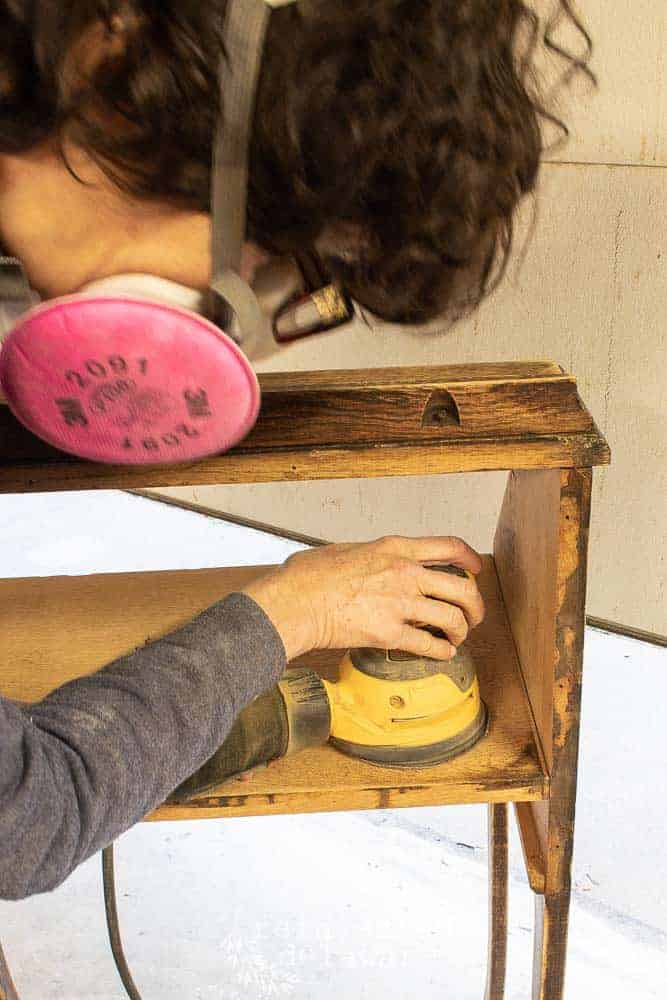 lady sanding a fold down secretary desk with DeWalt orbital sander