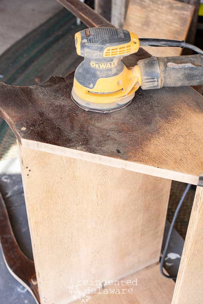 DeWalt orbital sander on top of fold down secretary desk laying on its side