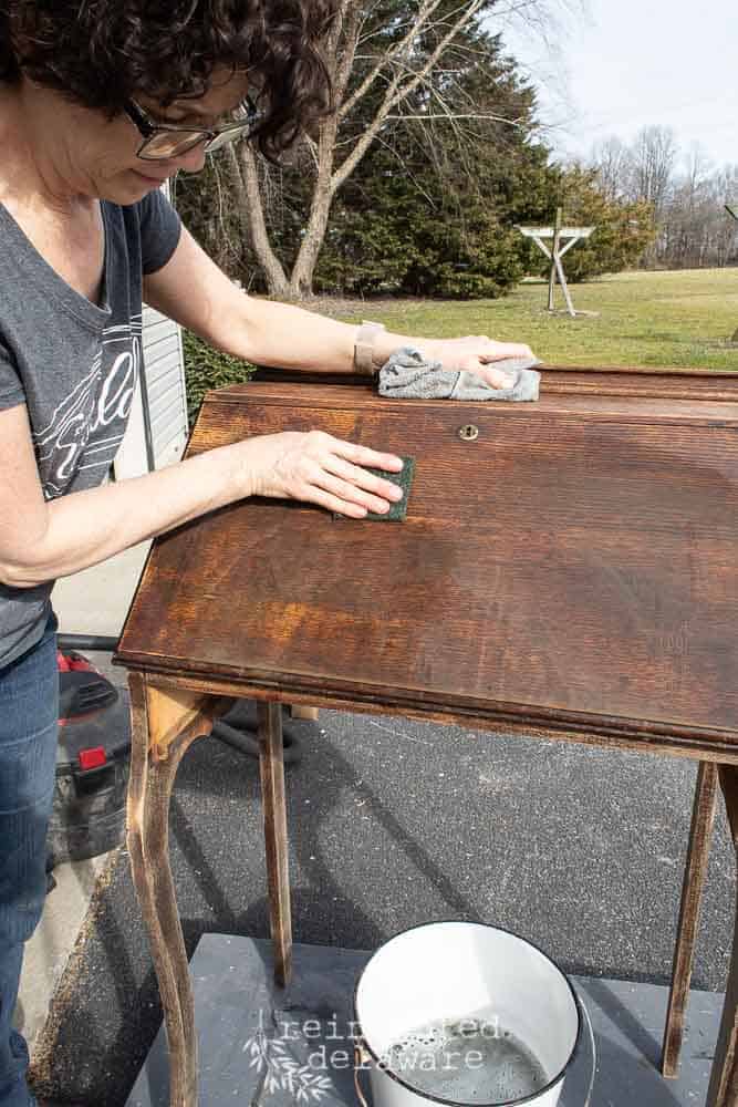 lady scrubbing a fold down secretary desk