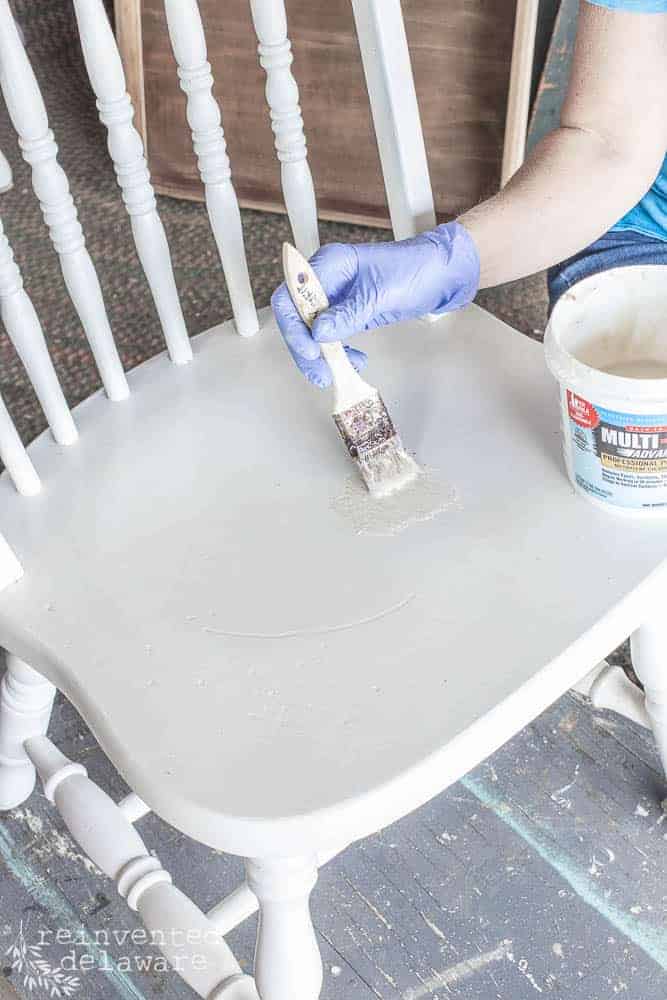 lady using paint remover on wood furniture