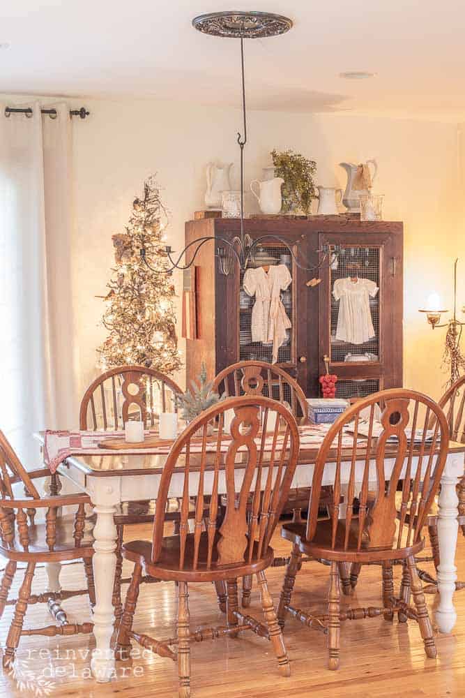 dining room showing Christmas tree, dining set and large vintage storage cabinet