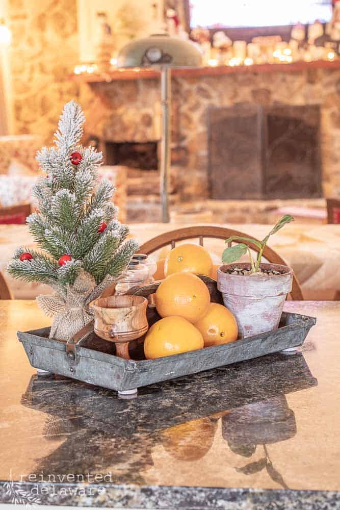 vintage metal tool caddy with small Christmas tree, oranges, salt & pepper shakers used as kitchen island centerpiece