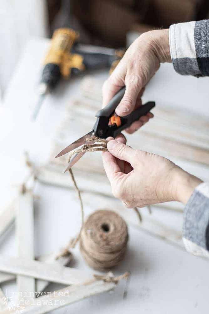 cutting lengths of twine to prepare for tying the stars