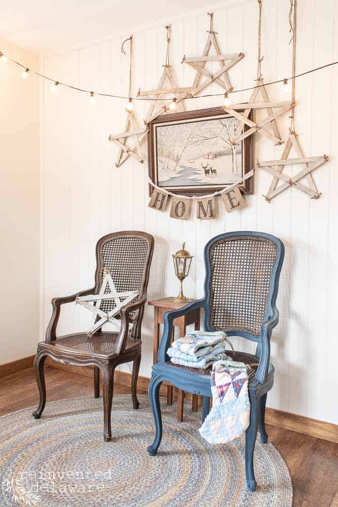two wicker chairs with handmade farmhouse style stars hanging above them and around a painting
