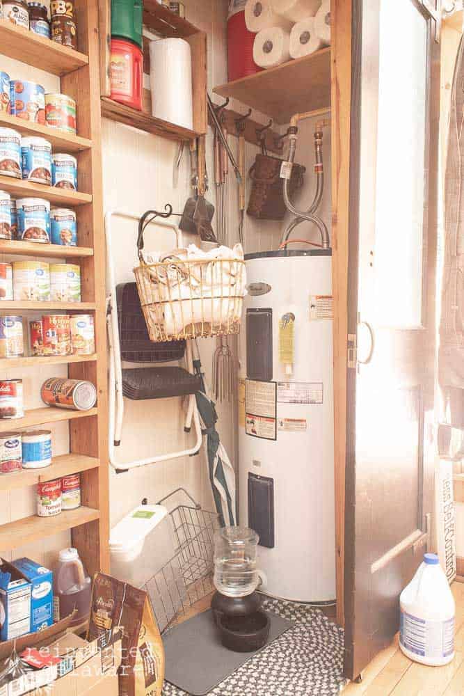 messy area in pantry closet with laundry items and hot water heater