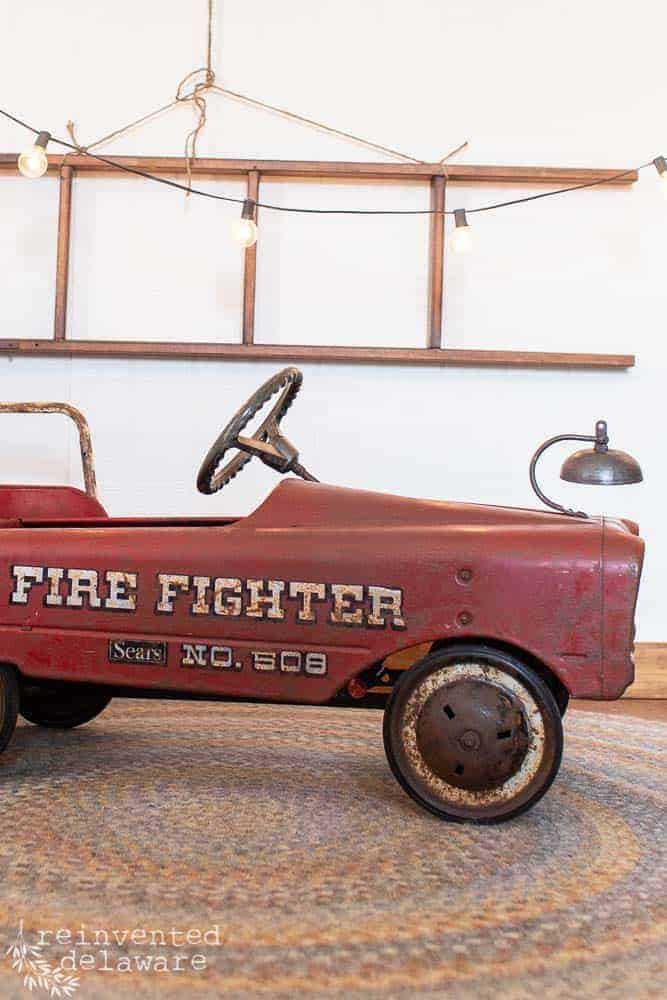 side view of antique metal toy fire truck with patina