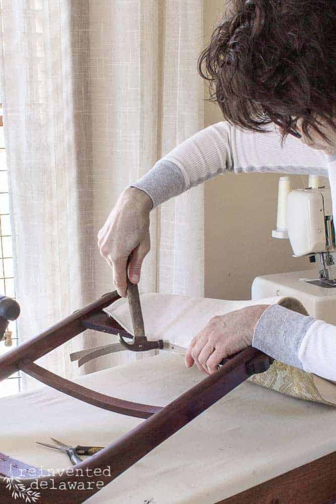 lady demonstrating how to attach upholstery tack strip on rocking chair