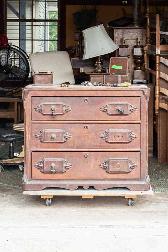 antique gentlemen's dresser before makeover sitting in workshop