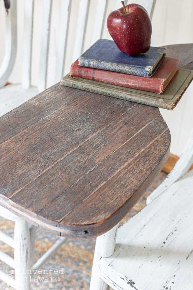 close up of desk area on desk antique desk chair staged with red apple on stack of vintage books