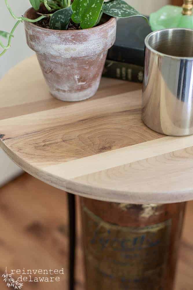 close-up of wood top made from a barstool and used as top of upcycled fire extinguisher converted to a side table