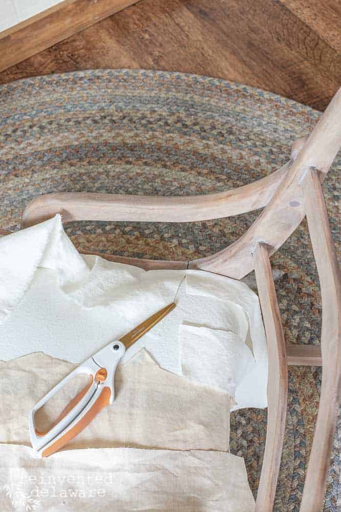 rocking chair with fabric and scissors laying on the seat of the chair