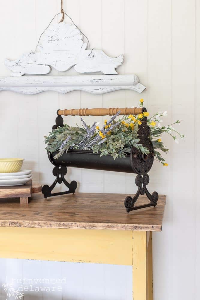 antique repurposed paper roller with faux florals inside