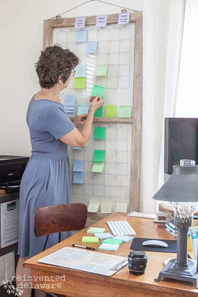 lady showing how to use a large content calendar that hangs on the wall