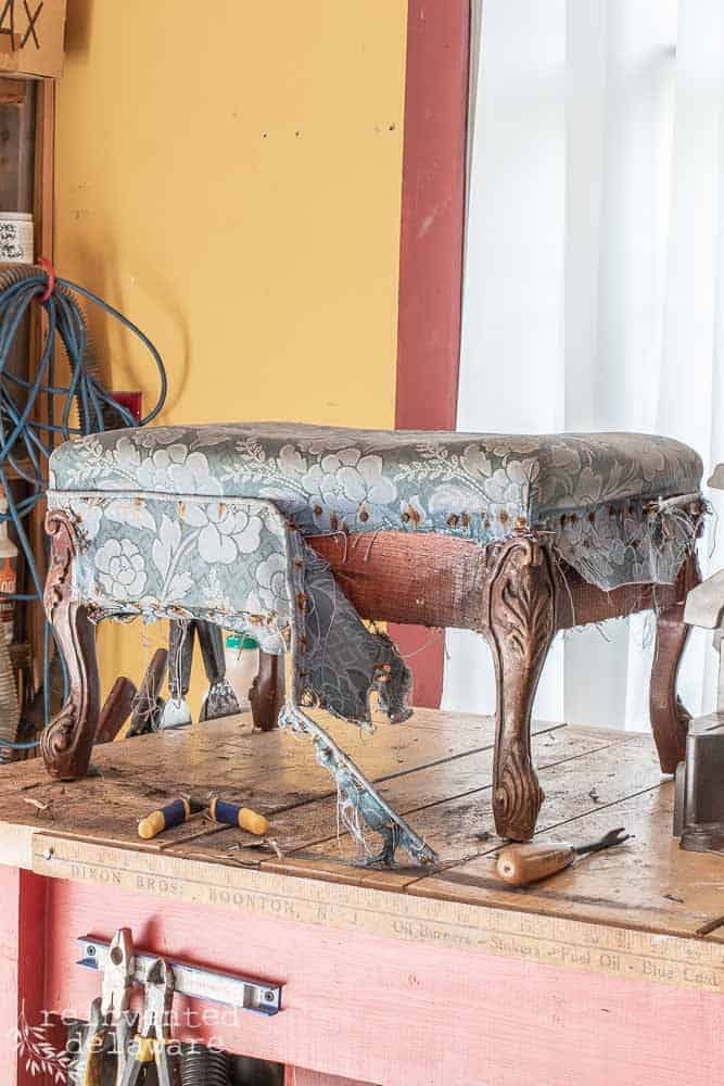 antique footstool with fabric being removed in how to upholster a footstool blogpost