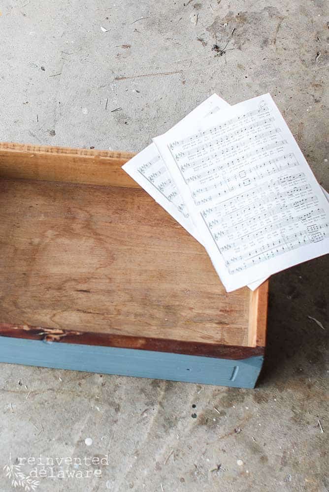 washstand drawer sitting on floor with sheet music on top ready to be applied with mod podge