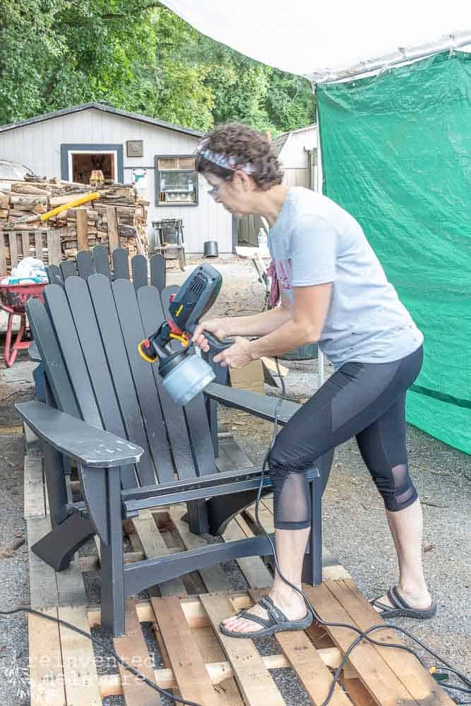 lady using Wagner Flexio 2000 power sprayer to spray paint an Adirondack chair