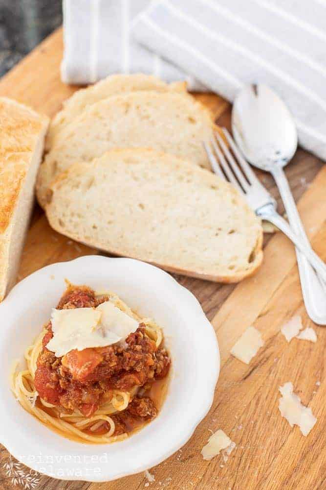 top view of prepared spaghetti sauce with bread and silverware in the background