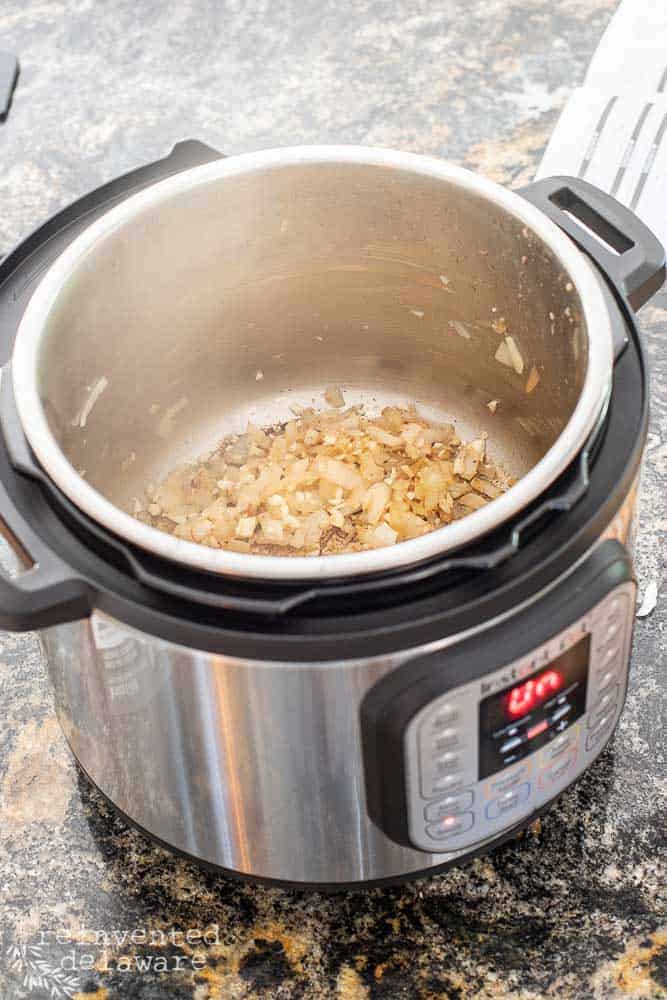 Instant Pot with onions browning on the inside of the pot