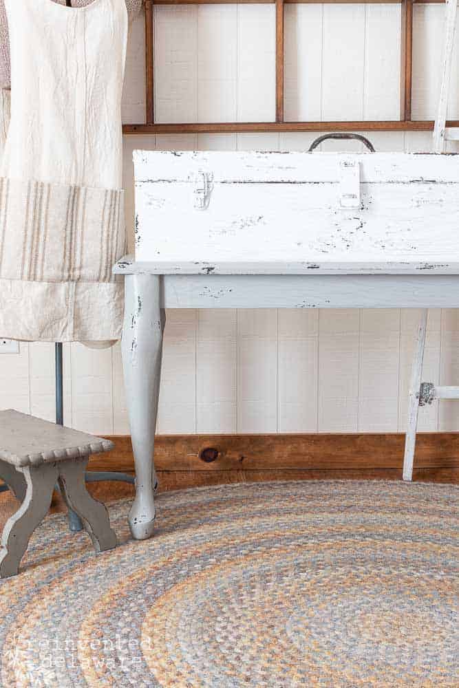 front view of an upcycled wood tool chest staged with a foot stoor and dress form with an apron on it.