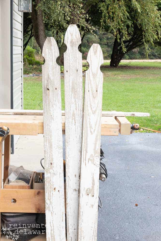 three reclaimed picket fence boards leaning on a workbench