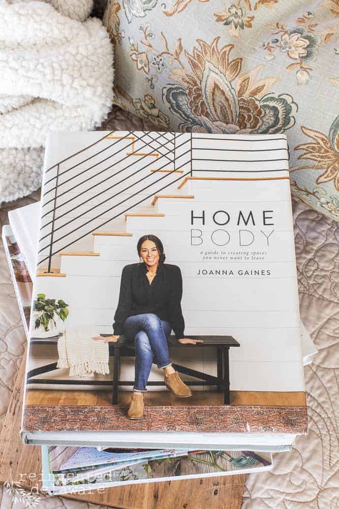 Home Body book by Joanna Gaines on top of other farmhouse style home decor books.
