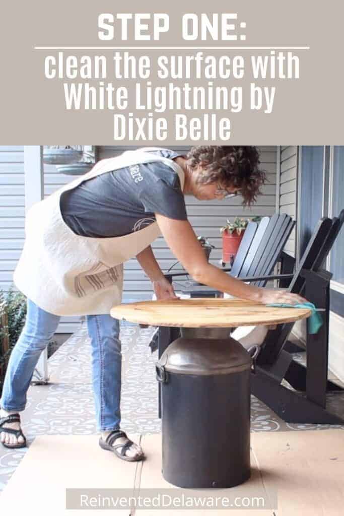 Graphic with text overlay: Step One: clean the surface with White Lightning by Dixie Belle" and lady cleaning a table top.
