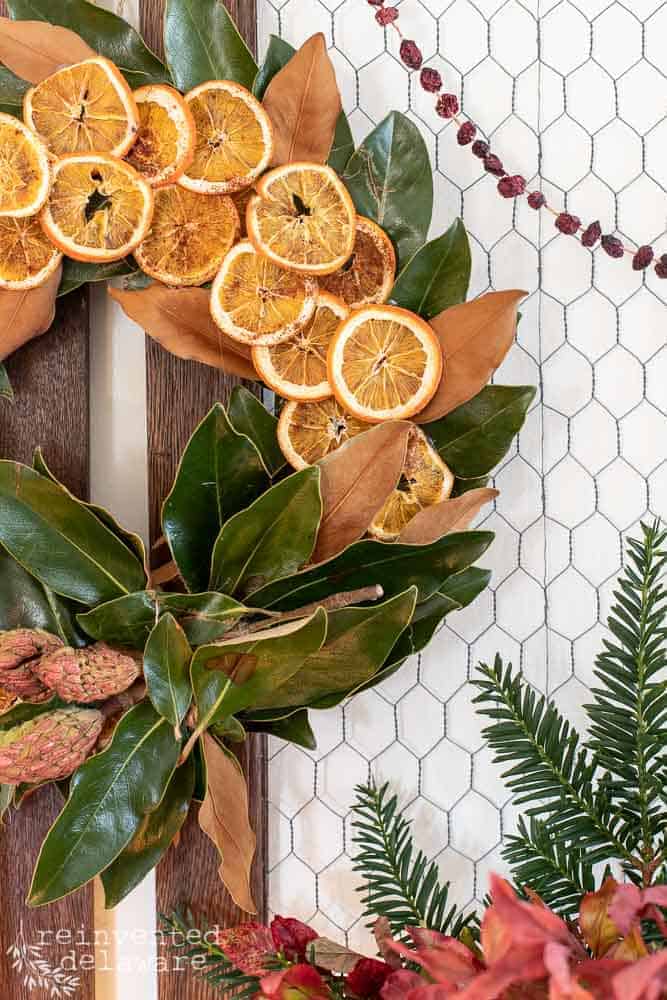Close up of easy diy magnolia wreath with orange slices hanging on the wall.
