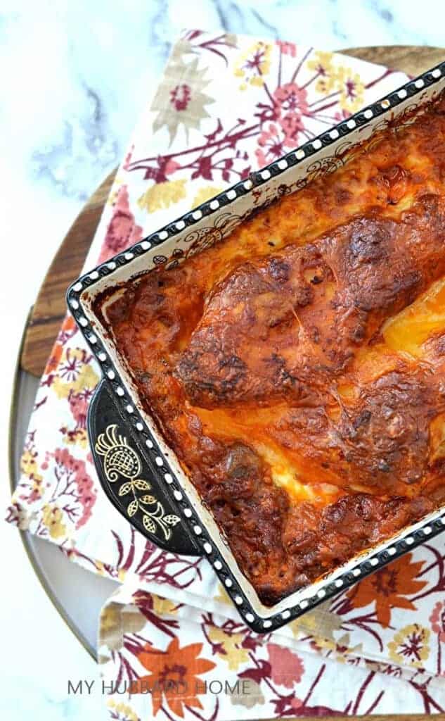 Top view of a homemade lasagna in a decorative cassorole dish with a floral print table linen.