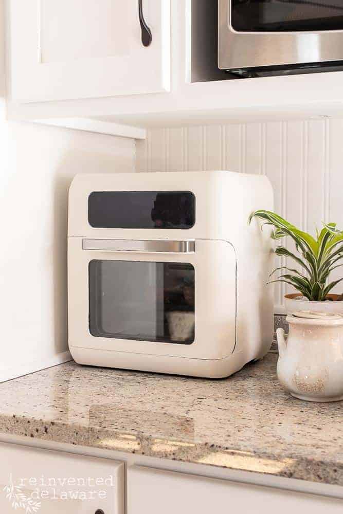 Side view of a painted air fryer sitting on a kitchen counter.