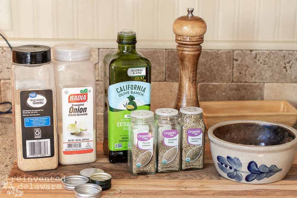 Ingredients needed for an easy roasted chicken including galic, onion, thyme, sage and rosemary.