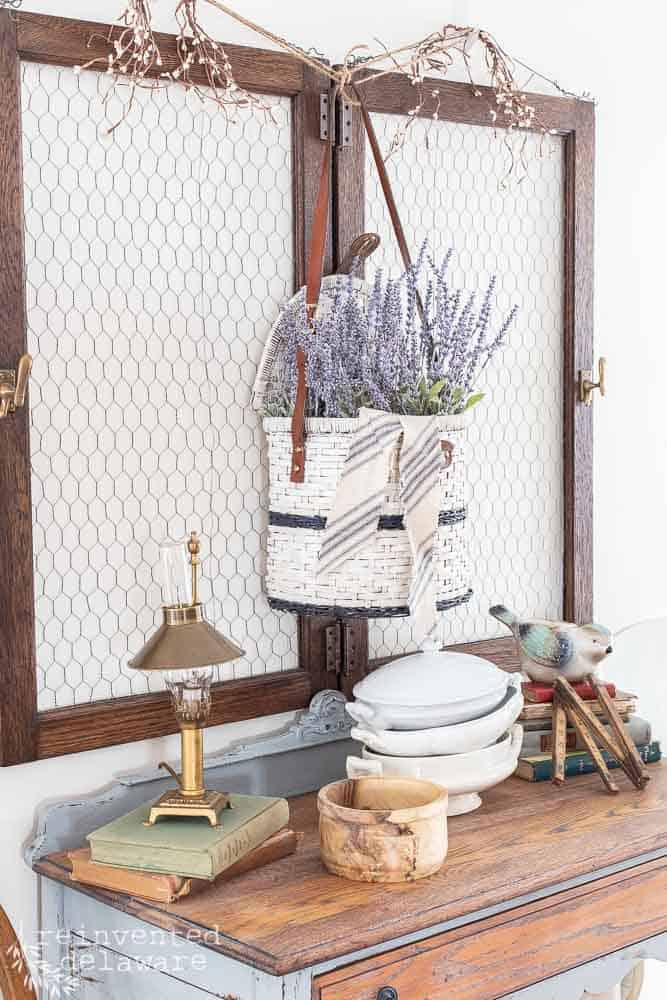Picnic Basket makeover displayed on the wall with faux lavender inside.