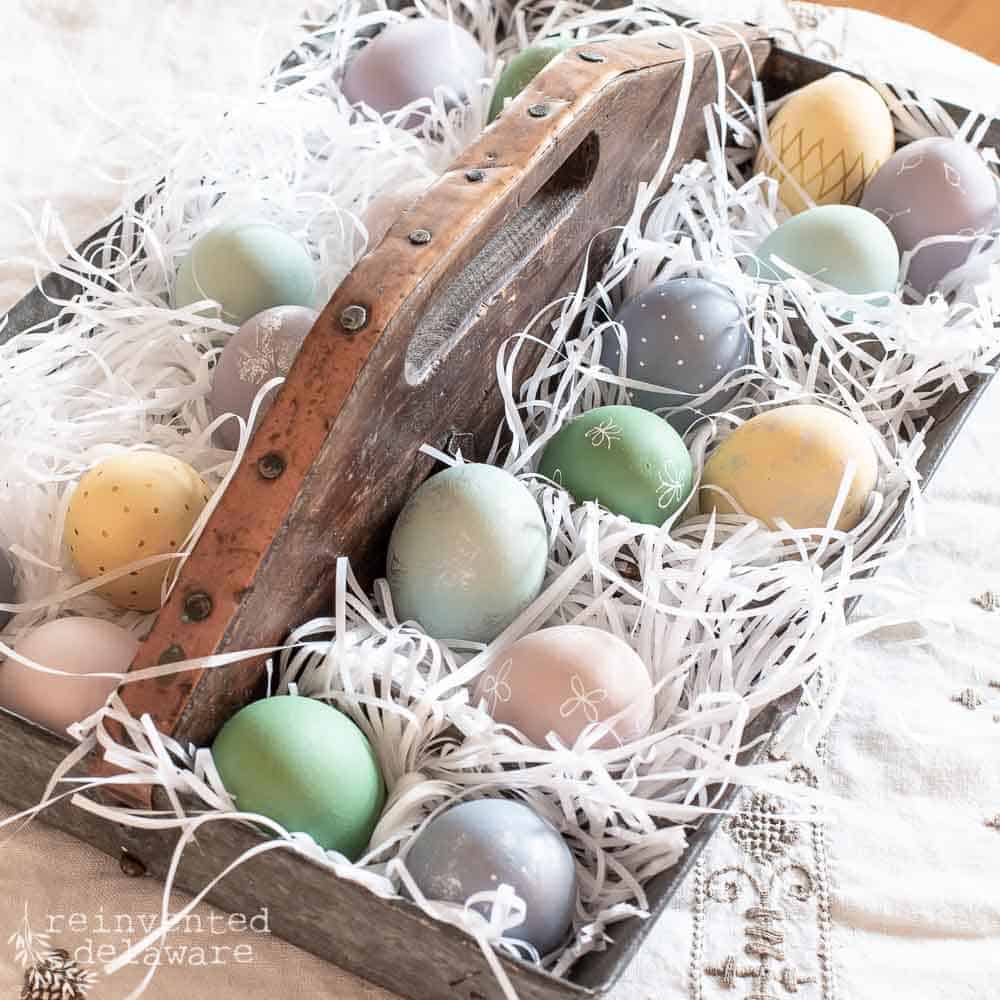 Hand painted wooden eggs in a vintage metal tool caddy.