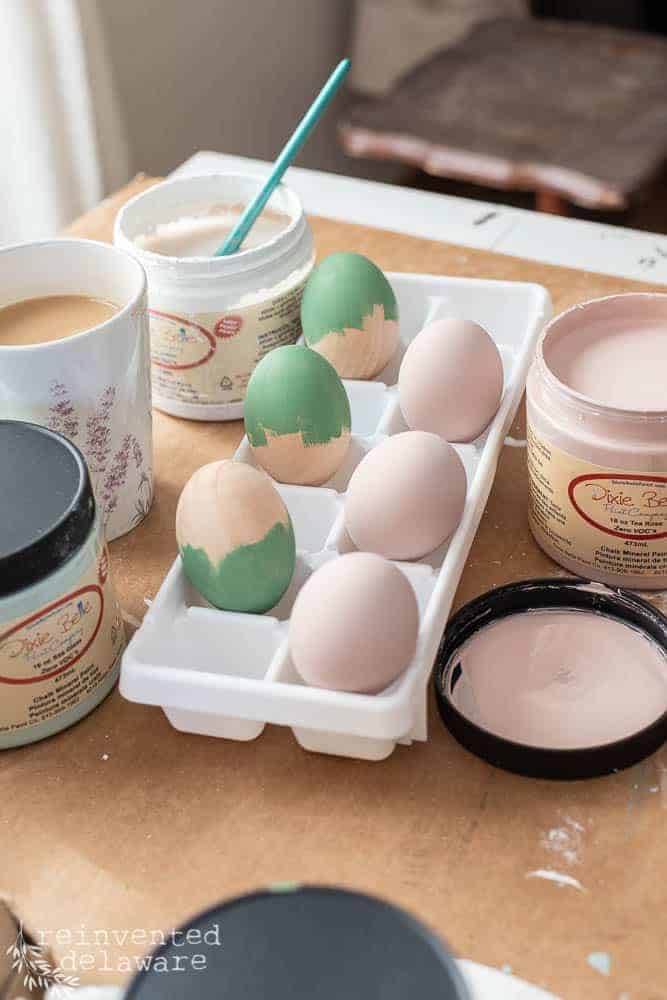 Eggs painted and sitting in an ice cube tray for an easy hand painted wooden eggs turtorial.