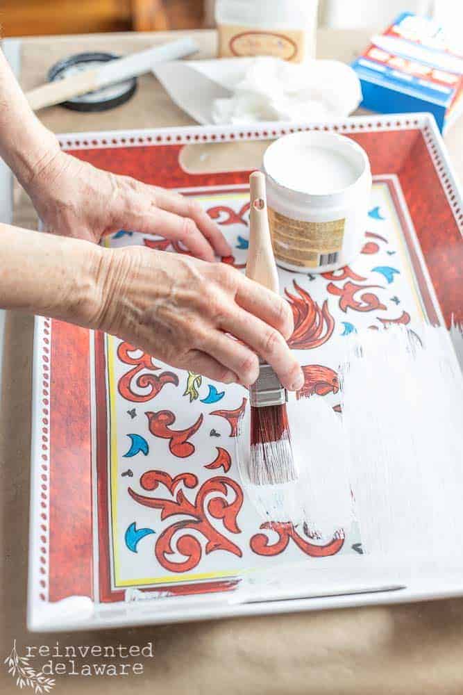 Lady painting Slick Stick on a melamine serving tray.