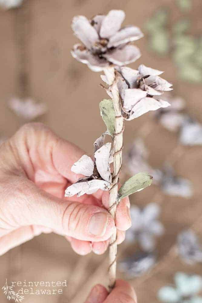 Close up view of pine cone petals painted as leaves and glued on for pine cone table decorations floral arrangement.