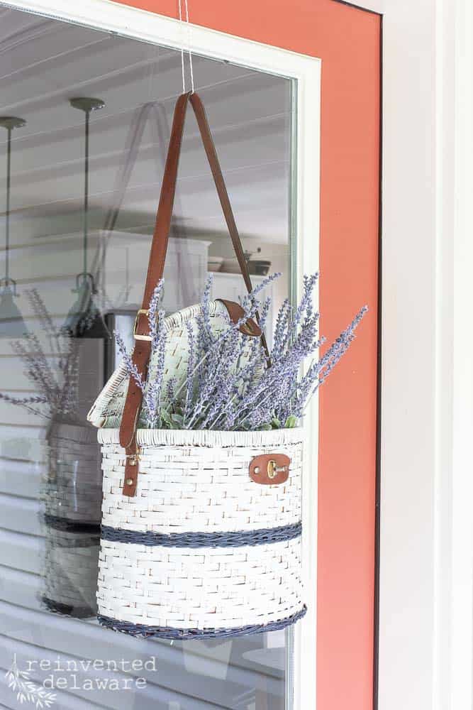 Picnic Basket filled with flowers hanging on front door for a front porch makeover.